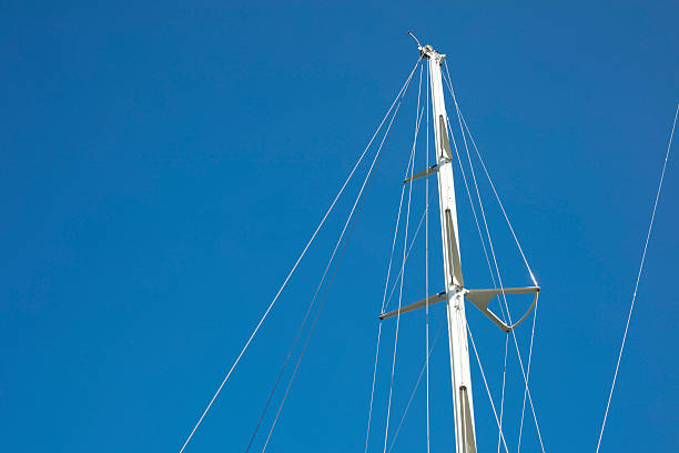 Detail of white masts of a boat with blue sky at the background