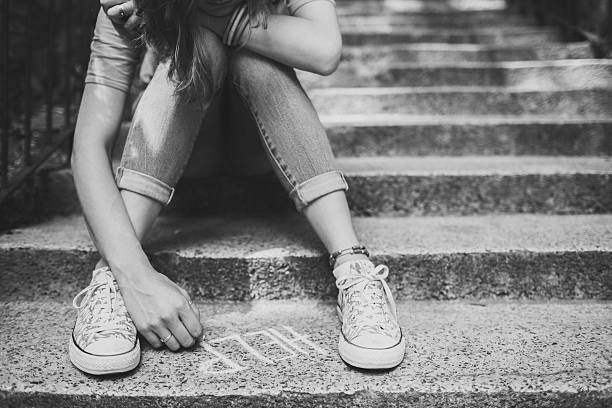 Depressed girl looking for help Teenage grl sitting on a staircase outside feeling depressed child abuse stock pictures, royalty-free photos & images