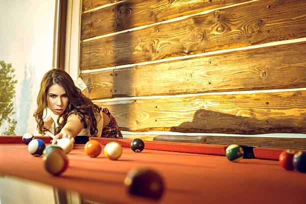 istock Pretty brunette girl playing billiard indoors 543663750