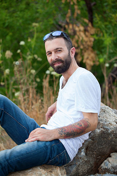 istock Bearded young man sitting on the rock 543664714