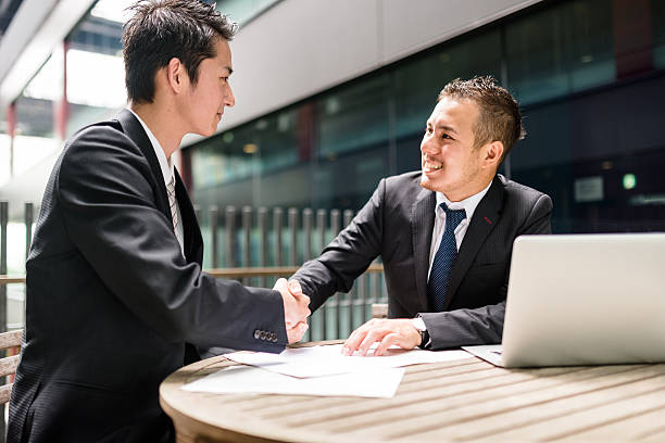 homem de negócios na reunião no distrito financeiro de construção - japanese culture asian ethnicity friendship computer imagens e fotografias de stock