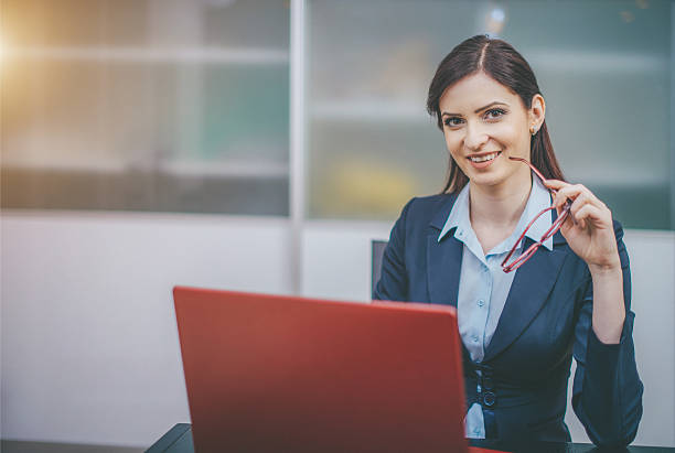 istock Smiling businesswoman using laptop in the office 543666348