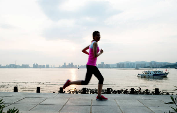 istock Young woman running at wooden boardwalk 543672782