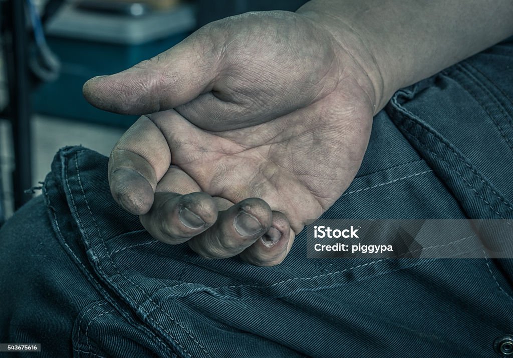 Dirty worker hand Low key oil dirt on hand of mechanic man hard worker at auto repair shop, selective focus (vintage effect) Rough Stock Photo