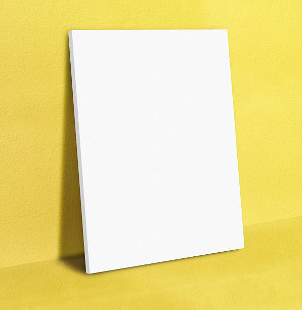 istock Blank white poster canvas frame leaning at yellow concrete paint 543675664