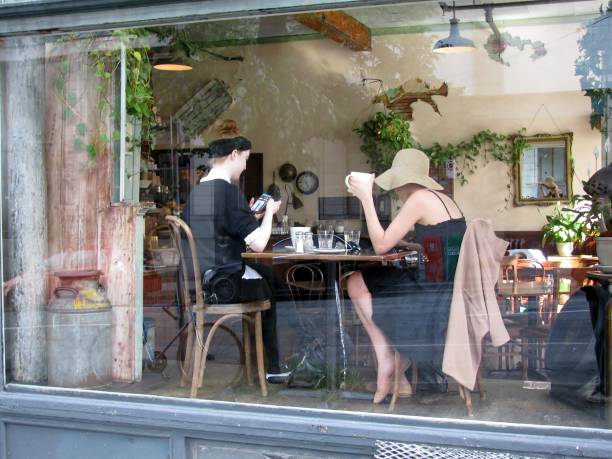 Vancouver, Canada - May 17, 2016: Two young girls at downtown Finch’s Tea & Coffee House having lunch seen through the glass of window.  