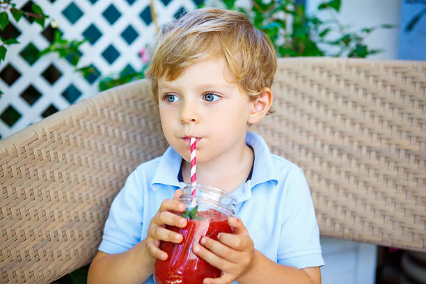 istock Little Kid boy drinking healthy fruit smoothie 543687050