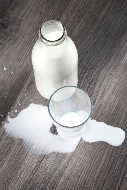 istock Spilled milk glass wooden table 543691078
