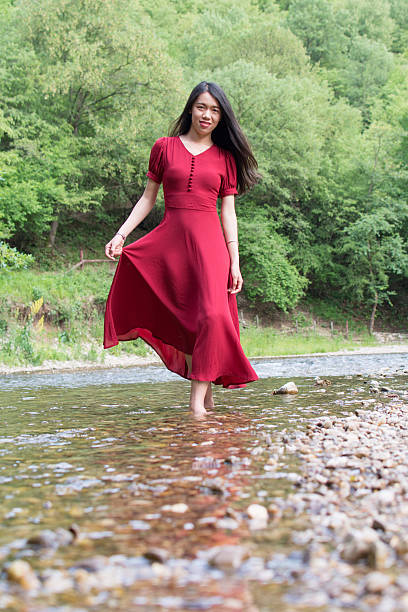 Fashionable woman walking in a river alone