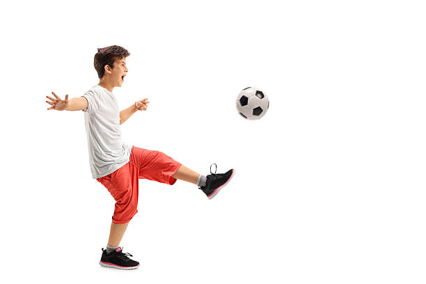 niño emocionado jugando al fútbol - volley kick fotografías e imágenes de stock