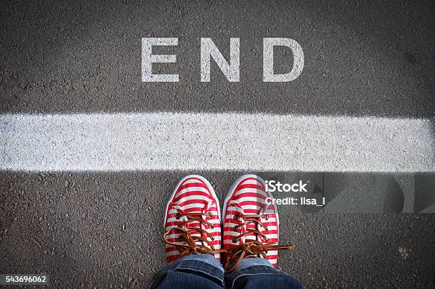 Person With Sneakers Standing In Front Of The End Message Stock Photo - Download Image Now