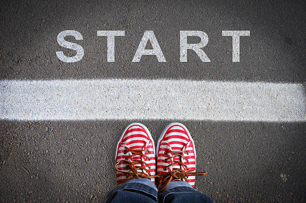 person with sneakers standing in front of the start message person with sneakers standing on the asphalt, in front of the start message endland stock pictures, royalty-free photos & images