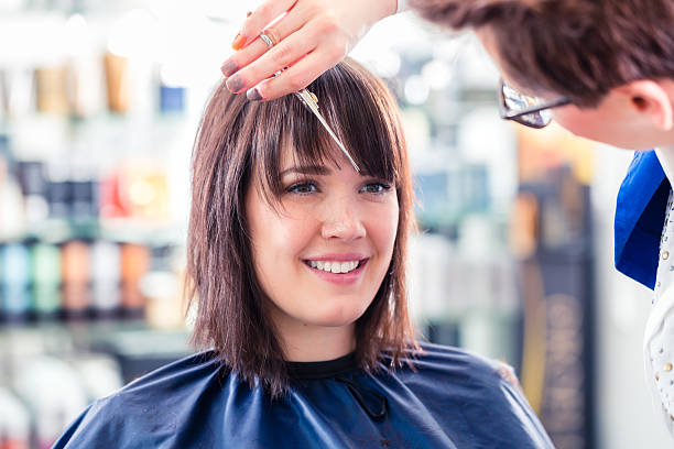 cabeleireiro cortando cabelo de mulher na loja - franja franjando - fotografias e filmes do acervo