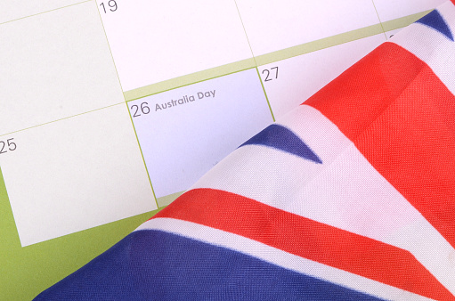 A calendar with Australia Day on the 26th of January. An Australian flag sits on top of the calendar.
