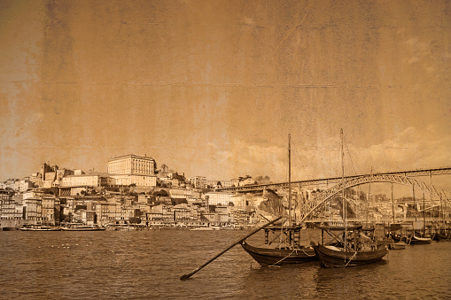 Postcard of the city Porto with its old town ribeira at river Douro with Rabelo Boats in the foreground, vintage style