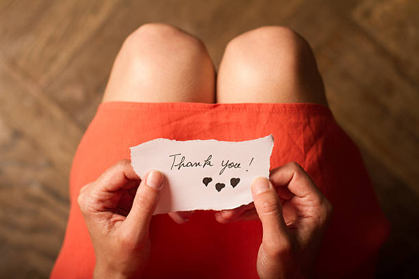 donna che tiene in mano una nota di ringraziamento - heart shape cute valentines day nostalgia foto e immagini stock