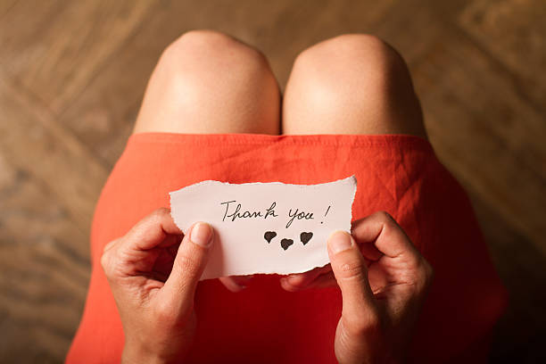 istock Woman holding a thank you note in her hand 543806338