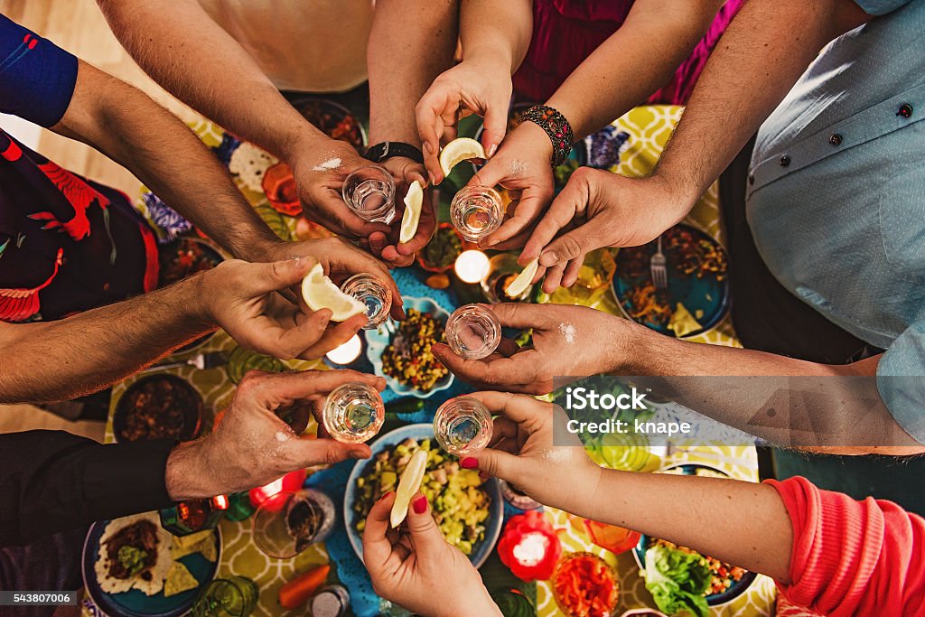 Friends drinking tequila at dinner party Tequila - Drink Stock Photo
