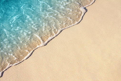 Soft wave of blue ocean on sandy beach, background