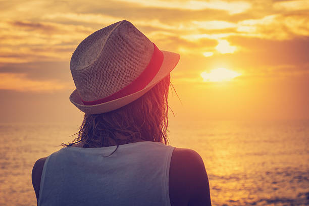 istock Girl watching the sunset/sunrise over sea. 543809300