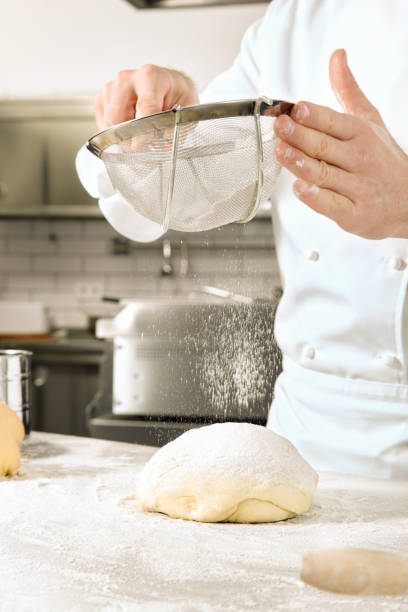 istock Chef sifting flour over a ball of dough 543810042