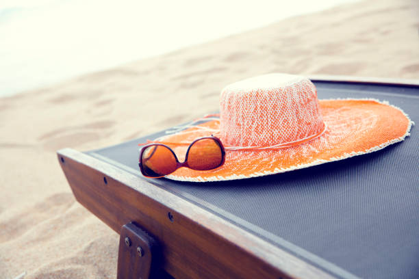 Sunglasses lying on a wooden tableSunglasses are on the straw hat