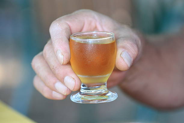 istock macedonian yellow rakia glass in a worker hand 543811602