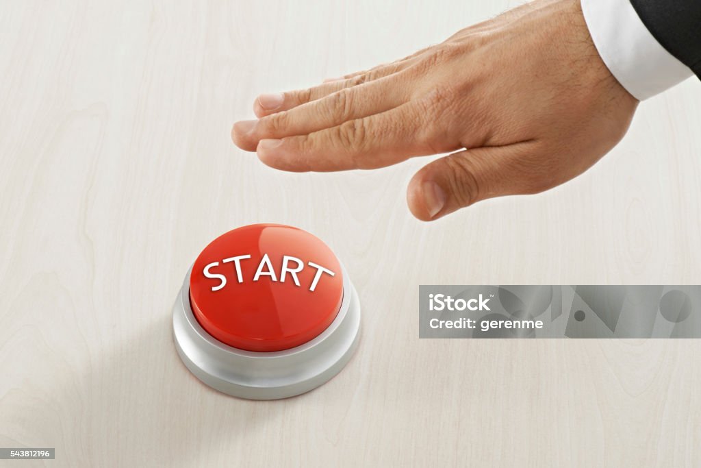 Start button businessman pressing "start" on wood background. Adult Stock Photo