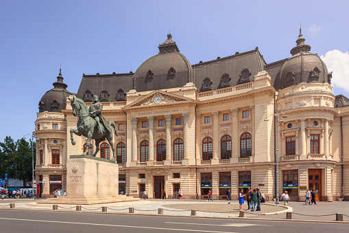 Bucharest, Romania - May 28, 2016: The Central University Library of Bucharest founded in 1895, on Revolution Square. In front of the building stands a statue of Carol I of Romania on horseback, designed in 1930 by croatian sculptor Ivan Mestrovic.