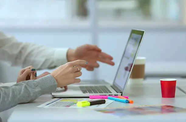 Photo of Team discussing Project pointing on Computer at modern Office