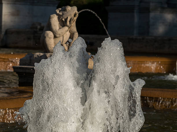 istock Water springing from a fountain in a park, statues in background 543818628
