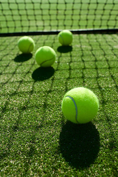 istock selective focus. tennis ball back light shadow on tennis grass 543820636