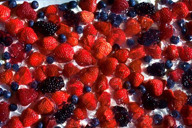 Strawberries, blueberries, blackberries and raspberries on cream, which mades isolated stock photo