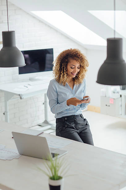 istock Latina Businesswoman Texting In Her Office 543822968