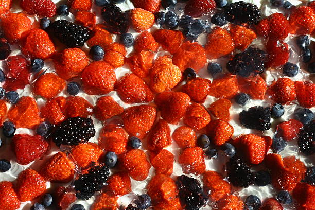 Strawberries, blueberries, blackberries and raspberries on cream, which mades isolated stock photo