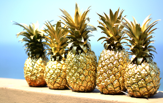 Gold pineapples with blue sky