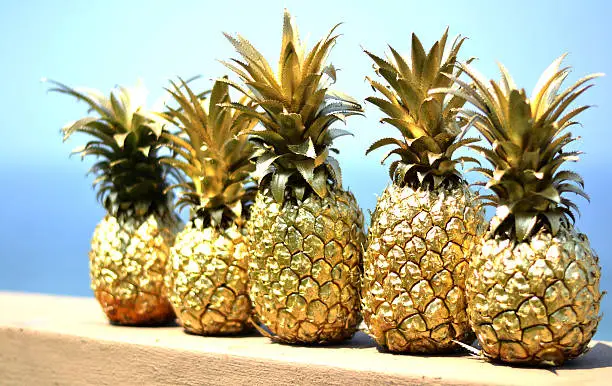 Gold pineapples with blue sky