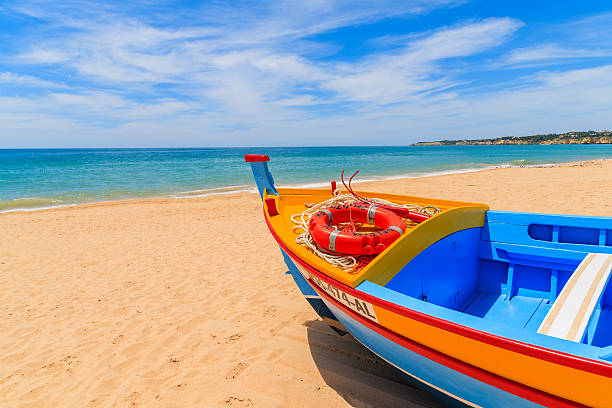 barca da pesca sulla spiaggia di sabbia - carvoeiro foto e immagini stock