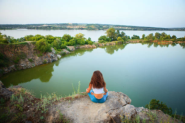 istock Young woman is practicing yoga near river 543834540