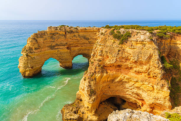 istock Rock cliff arches on Marinha beach 543836424
