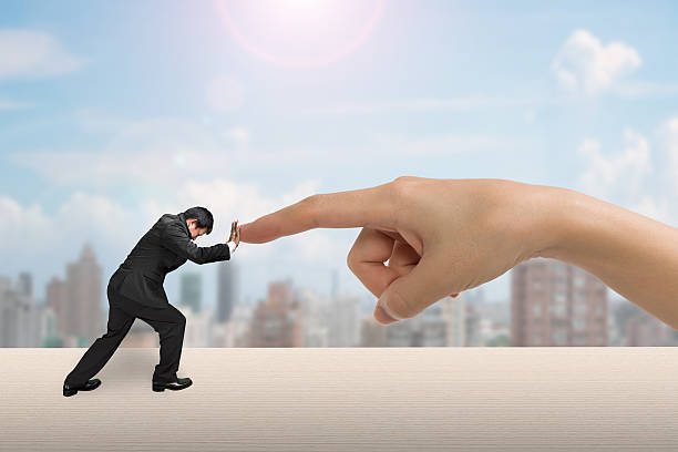 istock Small man pushing against big woman hand 543840342