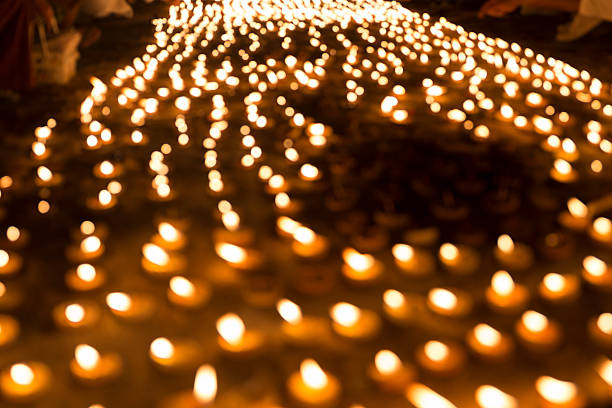 blur image of people light candle to pay respect to buddha relic at buddhist temple