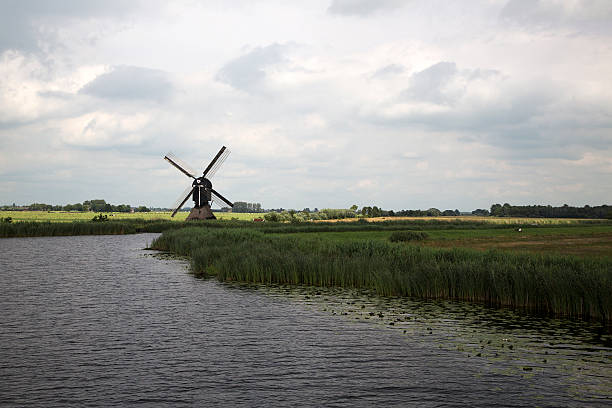 dutch countryside with windmilll along canal - alblasserwaard imagens e fotografias de stock