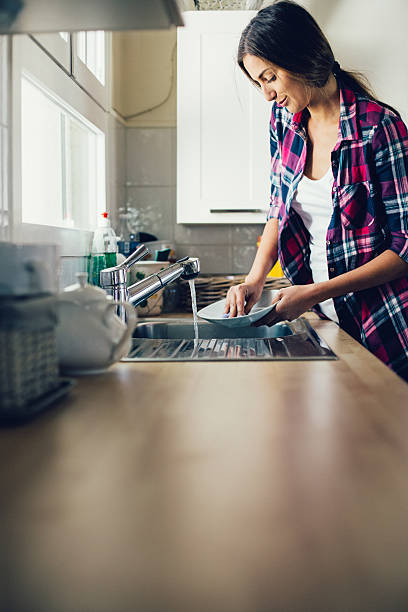 istock Young woman washing dishes 543978338