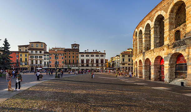 Verona Arena at Sunset Verona, Italy - September 25, 2015: Sunset over Ancient Roman coliseum Arena di Verona and walking tourists at Piazza Bra - Central Square of Verona. verona opera stock pictures, royalty-free photos & images