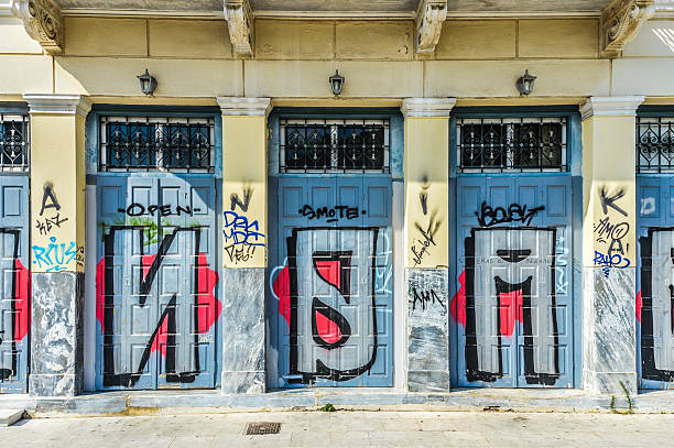 Retro style wooden door entrance with cracked paint and covered by dirty faded condition ads and posters, Bangkok Thailand.