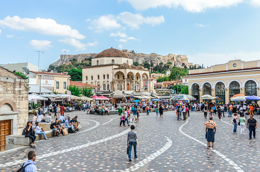 Athens, Greece - June 9, 2016: Monastiraki is a flea market neighborhood in the old town of Athens, Greece, and is one of the principal shopping districts in Athens. The area is named after Monastiraki Square, which in turn is named for the Church of the Pantanassa that is located within the square. Photo taken durign the day and contains many locals and tourists visiting the square.