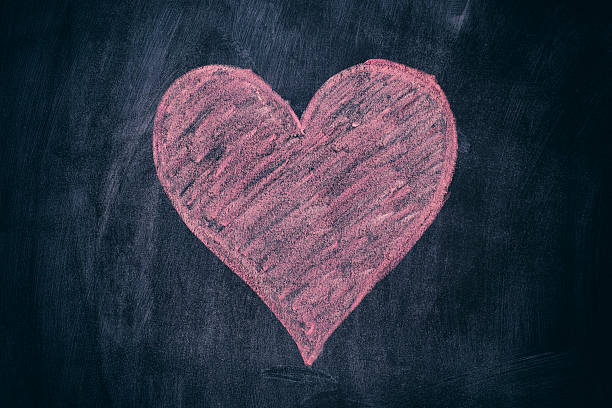 istock Pink heart shape on black chalkboard background 543980872