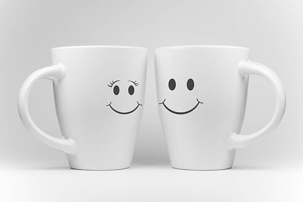 istock Two white mugs with facial expressions. 543981400