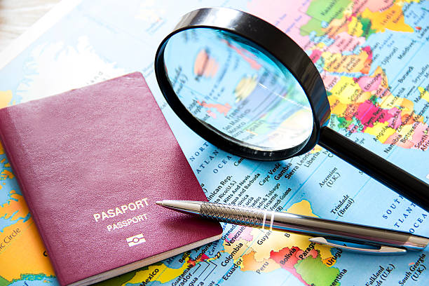 Travel planning over world map. Passport and magnifying glass stock photo